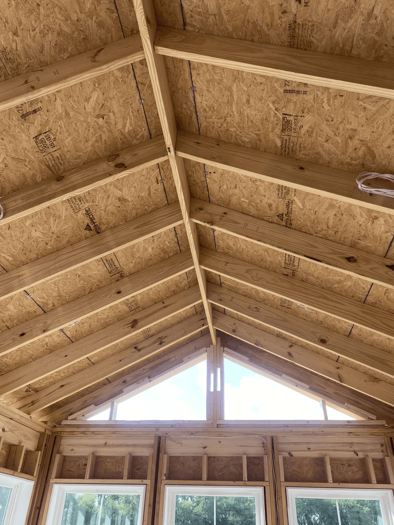 Interior view of exposed gabled roof framing during sunroom construction