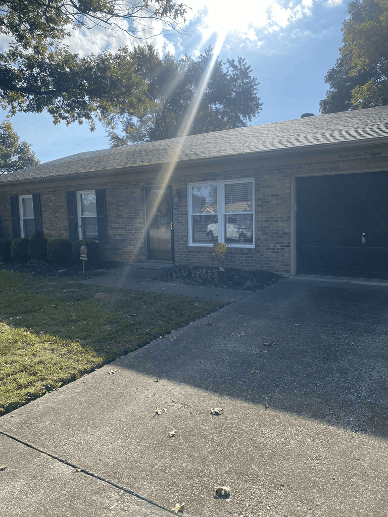 Brick home with a completed architectural shingle roof viewed from the driveway