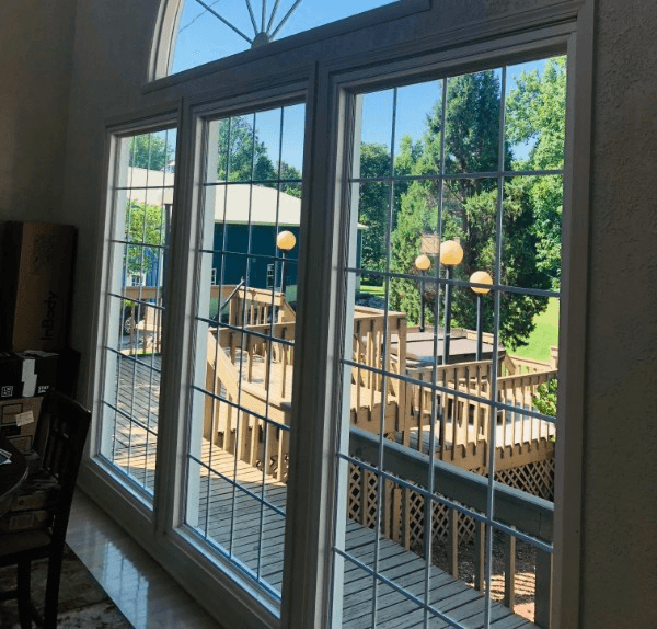 Large picture windows overlooking a backyard deck