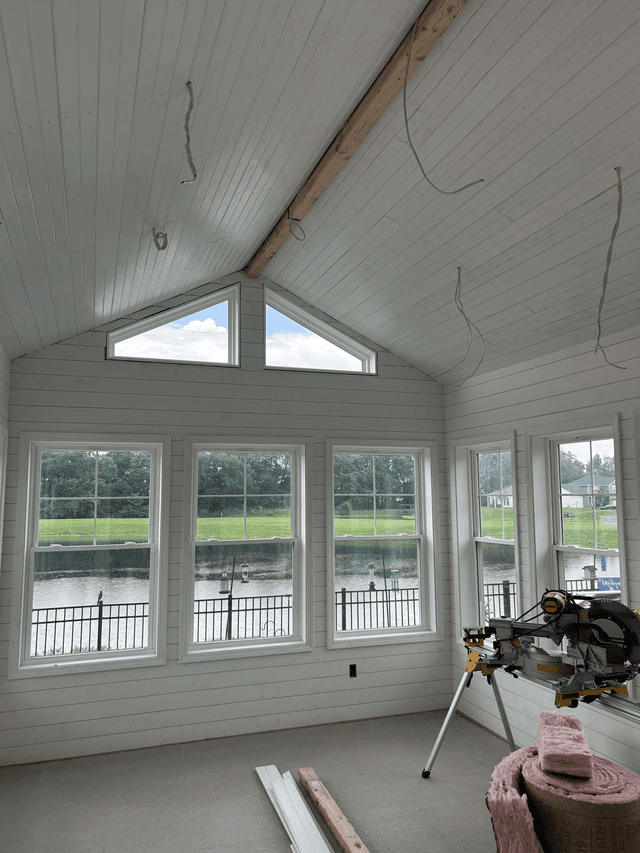 Sunroom interior with window trim and wall finishes being installed