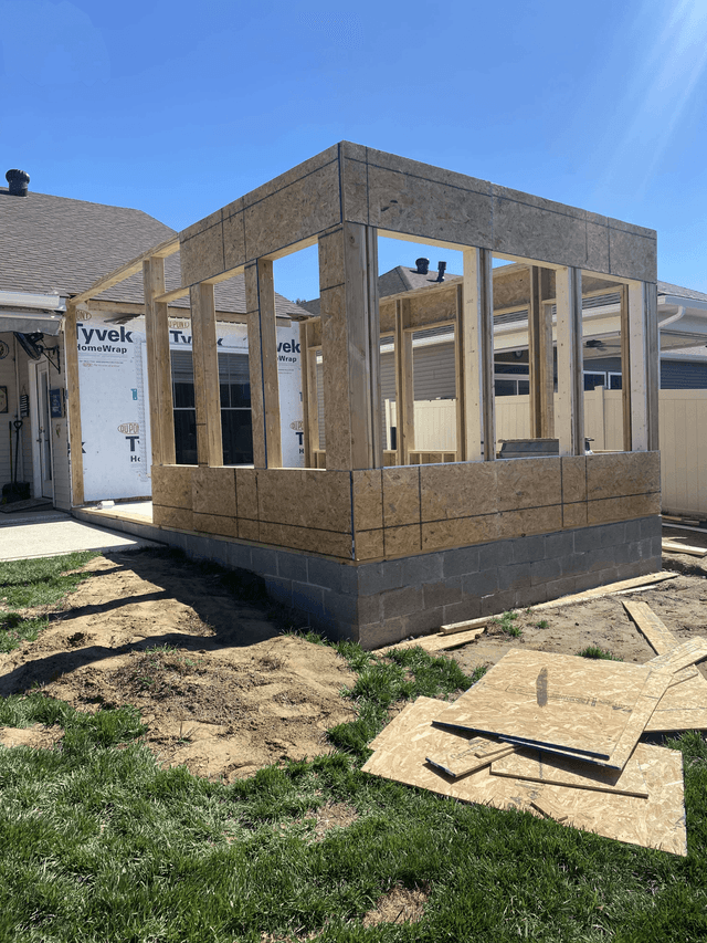 Early sunroom construction with framed walls on a concrete foundation
