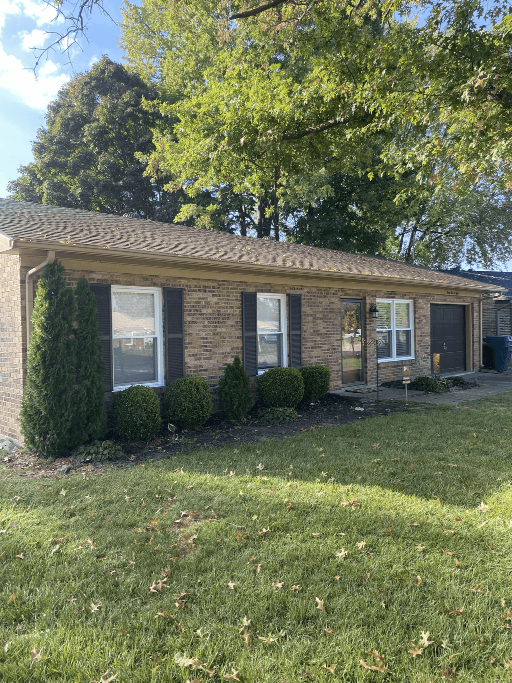 Completed dark architectural shingle roof on a brick home
